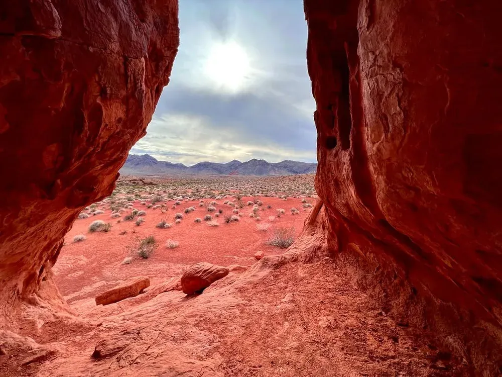 Desert plain framed by the walls of a red sandstone alcove in Valley of Fire State Park, Nevada